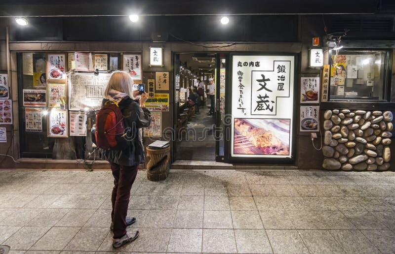 Tourist woman photographing restaurant Chiyoda Tokyo stock photo Tourist woman photographing restaurant Chiyoda Tokyo stock photo