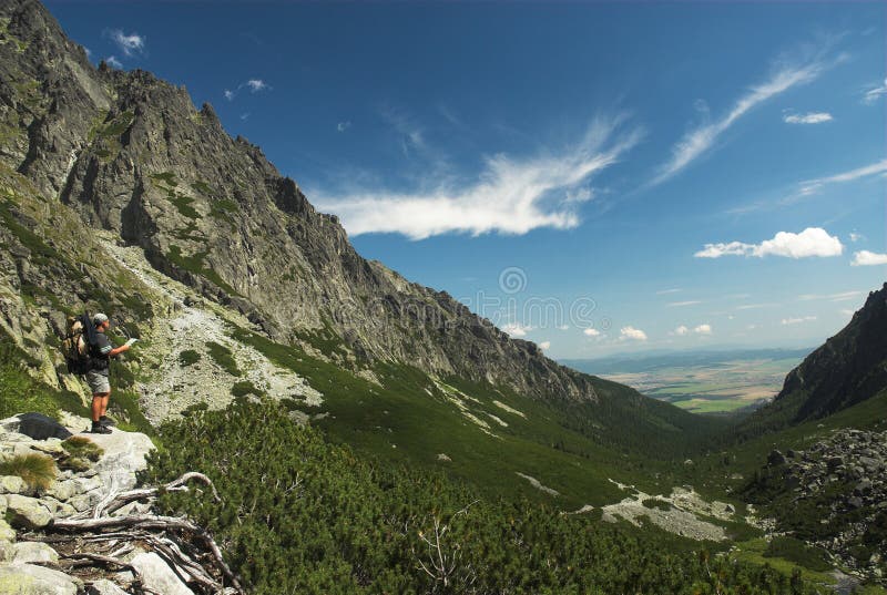 Touriste avec la carte en montagnes image libre de droits Touriste avec la carte en montagnes image libre de droits