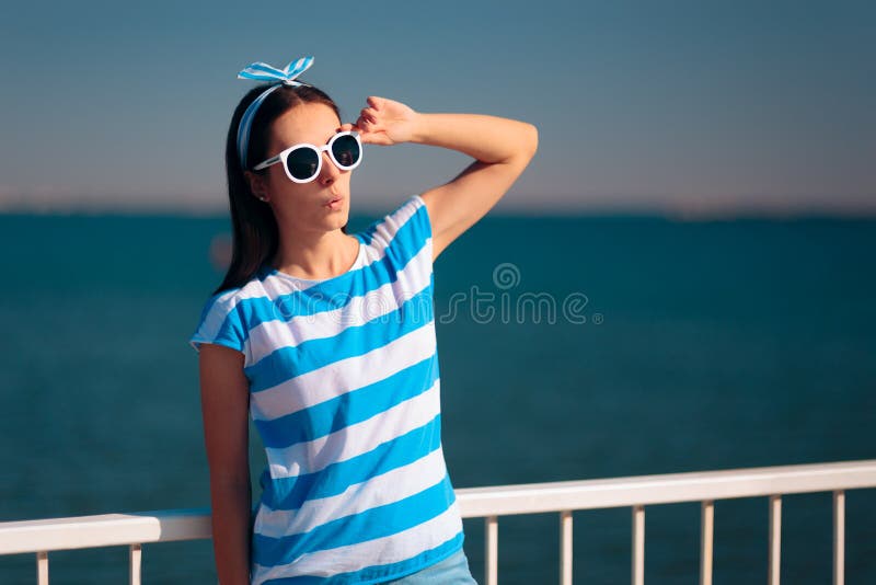Touriste f?minin gai avec le T-shirt et les lunettes de soleil d?pouill?s de marine image libre de droits Touriste f?minin gai avec le T-shirt et les lunettes de soleil d?pouill?s de marine image libre de droits