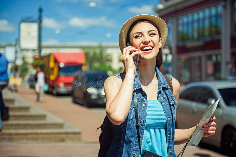 Touriste féminin heureux communiquant au téléphone photographie stock libre de droits Touriste féminin heureux communiquant au téléphone photographie stock libre de droits