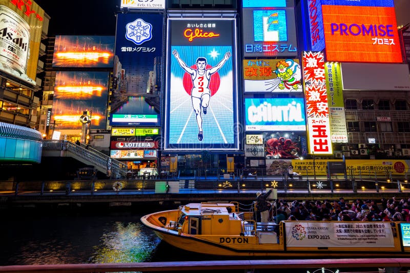 Touriste marchant dans la rue d'achats de nuit chez Dotonbori à Osaka, Japon photo libre de droits Touriste marchant dans la rue d'achats de nuit chez Dotonbori à Osaka, Japon photo libre de droits