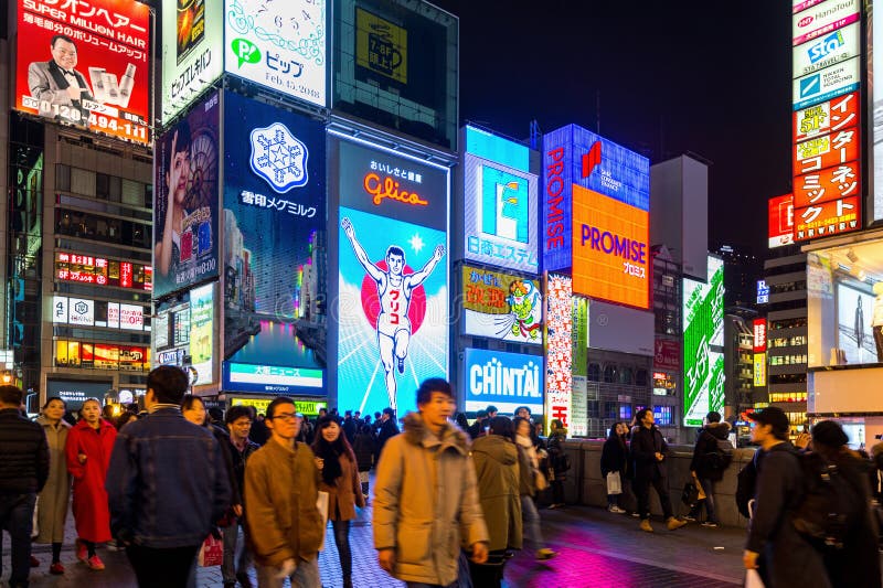 Touriste marchant dans la rue d'achats de nuit chez Dotonbori à Osaka, Japon photographie stock Touriste marchant dans la rue d'achats de nuit chez Dotonbori à Osaka, Japon photographie stock