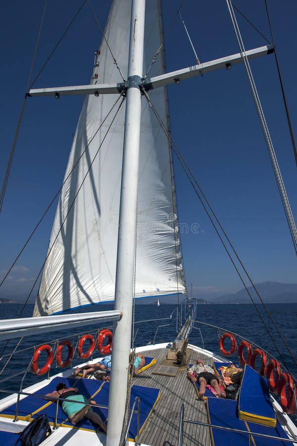 Touristen an Bord eines Kreuzfahrtbootes entspannen sich, während, weg segelnd auf das Mittelmeer vor der Türkis-Küste von der Tü lizenzfreies stockbild Touristen an Bord eines Kreuzfahrtbootes entspannen sich, während, weg segelnd auf das Mittelmeer vor der Türkis-Küste von der Tü lizenzfreies stockbild
