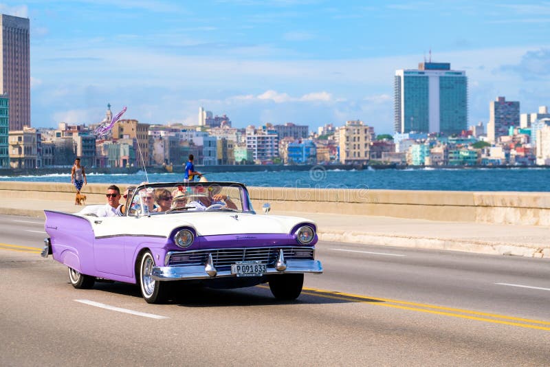 Touristen, die eine Fahrt auf einen Oldtimer am Malecon-avenu genießen lizenzfreie stockfotografie Touristen, die eine Fahrt auf einen Oldtimer am Malecon-avenu genießen lizenzfreie stockfotografie