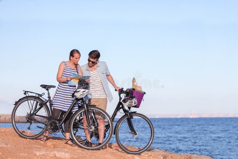 Touristen mit den Fahrrädern, die Karte betrachten