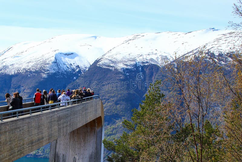 Touristes appréciant le scenary étonnant du fjord sur le point de vue de Stegastein image stock Touristes appréciant le scenary étonnant du fjord sur le point de vue de Stegastein image stock