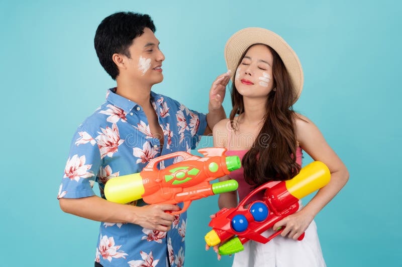 Touristes asiatiques en vêtements d'été jouent dans l'eau avec des pistolets en plastique et de la poudre pendant le festival song photo stock