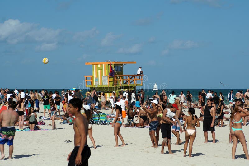 South Beach packed with tourists on Spring Break, with a yellow lifeguard stand in the center, in Miami, Florida, USA. South Beach packed with tourists on Spring Break, with a yellow lifeguard stand in the center, in Miami, Florida, USA