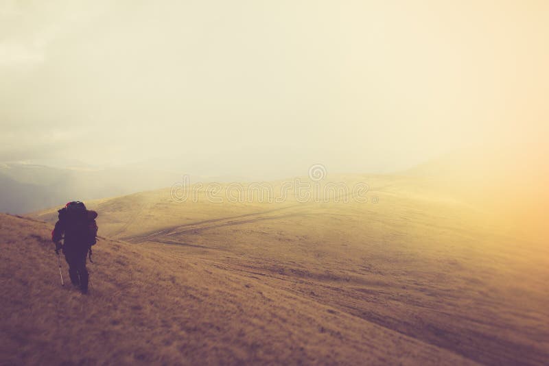 Tourists with backpacks climb to the top of the mountain in fog. royalty free stock image Tourists with backpacks climb to the top of the mountain in fog. royalty free stock image