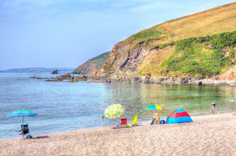 Tourists Coloured umbrellas Portwrinkle beach Whitsand Bay Cornwall England United Kingdom in colourful HDR