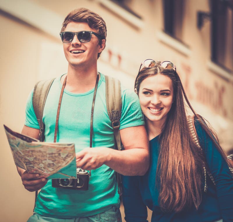 Young beautiful couple tourists with map in old city. Young beautiful couple tourists with map in old city