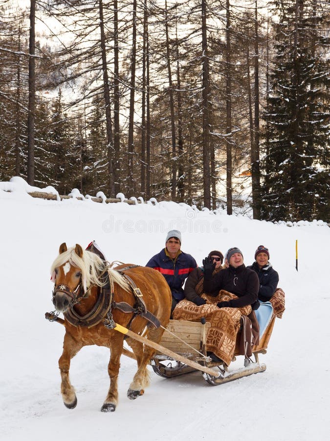 REIN IN TAUFERS, ITALY - JANUARY 23: Tourists enjoy a ride on a horse-drawn sleigh on January 23, 2012, in Rein in Taufers, South Tyrol, Italy. The village is a popular winter vacation destination. REIN IN TAUFERS, ITALY - JANUARY 23: Tourists enjoy a ride on a horse-drawn sleigh on January 23, 2012, in Rein in Taufers, South Tyrol, Italy. The village is a popular winter vacation destination.