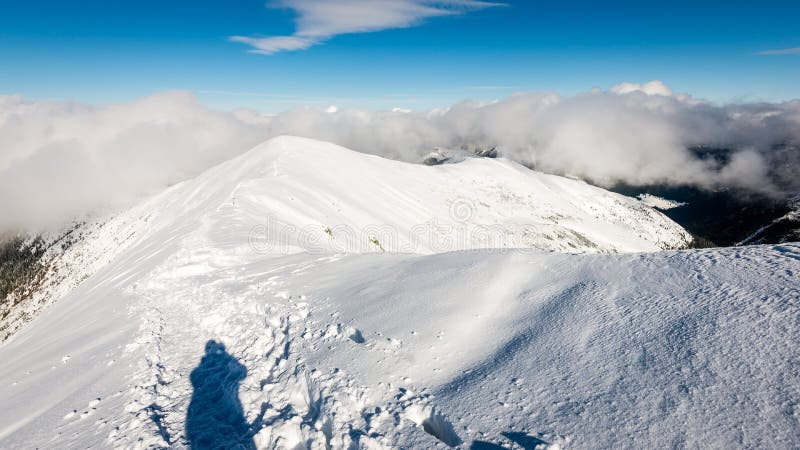Turisté si užívají vysoké hory ve sněhu za slunečného dne