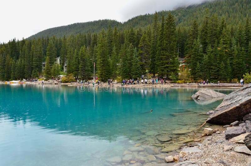 Tourists at the glacier blue water of the Morain Lake