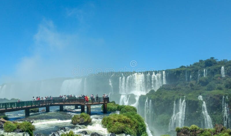 Tourists at Iguazu Falls, one of the world`s great natural wonders, on the border of Brazil and Argentina. royalty free stock photography Tourists at Iguazu Falls, one of the world`s great natural wonders, on the border of Brazil and Argentina. royalty free stock photography