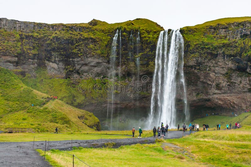 Tourists near Seljalandsfoss waterfall in Iceland