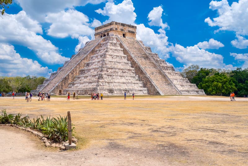 CHICHEN ITZA,MEXICO - APRIL 17,2019 : Tourists next to the Pyramid of Kukulkan on a beautiful day at the ancient mayan city of Chichen Itza, america, antique, antiquity, archeological, archeology, architecture, attraction, building, castle, central, civilization, culture, destination, famous, heritage, historic, history, holiday, icon, indian, kukulcan, landmark, riviera, mexican, monument, old, people, person, religion, religious, ruin, stone, temple, tourism, travel, vacation, yucatan, itzamexico, 172019. CHICHEN ITZA,MEXICO - APRIL 17,2019 : Tourists next to the Pyramid of Kukulkan on a beautiful day at the ancient mayan city of Chichen Itza, america, antique, antiquity, archeological, archeology, architecture, attraction, building, castle, central, civilization, culture, destination, famous, heritage, historic, history, holiday, icon, indian, kukulcan, landmark, riviera, mexican, monument, old, people, person, religion, religious, ruin, stone, temple, tourism, travel, vacation, yucatan, itzamexico, 172019