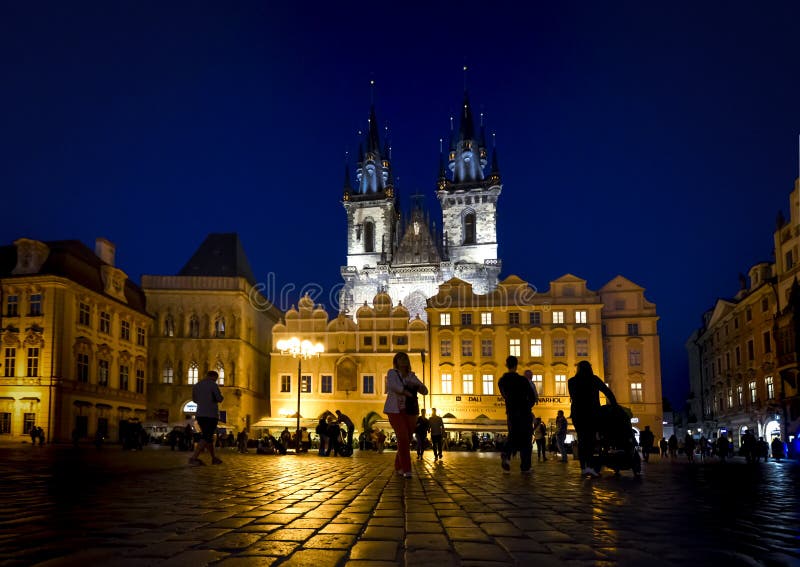 Tourists sightsee late at night in Old Town Square under the lighted towers of Our Lady Before Tyn Church in the Prague, Czech Re royalty free stock photography Tourists sightsee late at night in Old Town Square under the lighted towers of Our Lady Before Tyn Church in the Prague, Czech Re royalty free stock photography