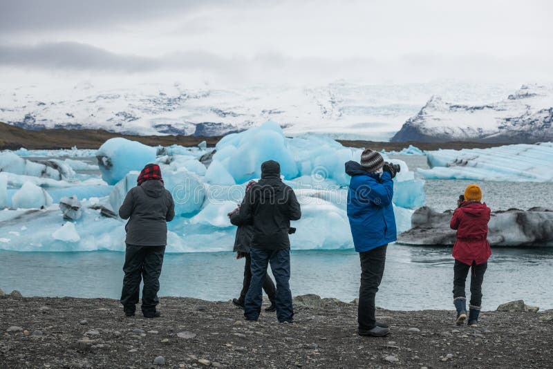 Tourists taking photos of deep blue icebergs in Jokulsarlon lagoon, Iceland royalty free stock photos Tourists taking photos of deep blue icebergs in Jokulsarlon lagoon, Iceland royalty free stock photos