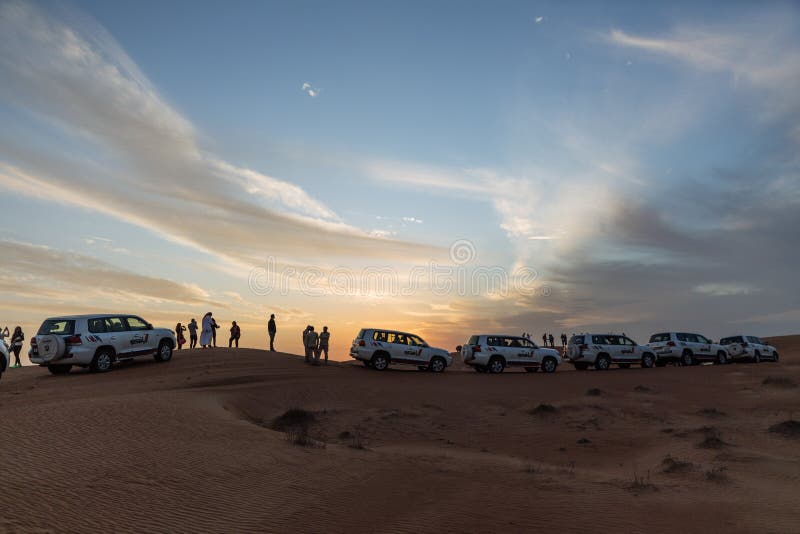 Tourists with travel cars parking for see the sun down in the evening in the great desert at Dubai