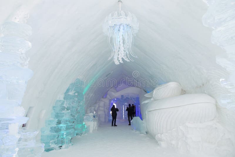 Tourists visiting and taking photos of a marine themed great hall in the world-renowned seasonal Ice Hotel