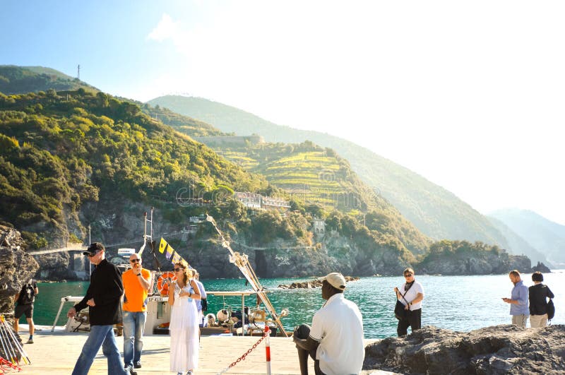 Tourists wait at the dock for the next tour boat at the harbor of Monterosso al Mare, Italy, part of the Cinque Terre. royalty free stock photos Tourists wait at the dock for the next tour boat at the harbor of Monterosso al Mare, Italy, part of the Cinque Terre. royalty free stock photos