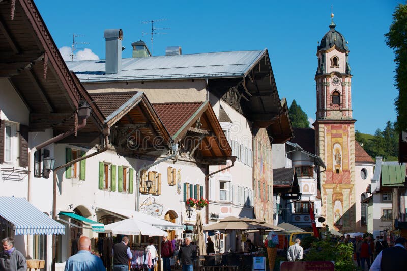 Tourists walk by the street of Mittenwald, Germany. stock photo Tourists walk by the street of Mittenwald, Germany. stock photo