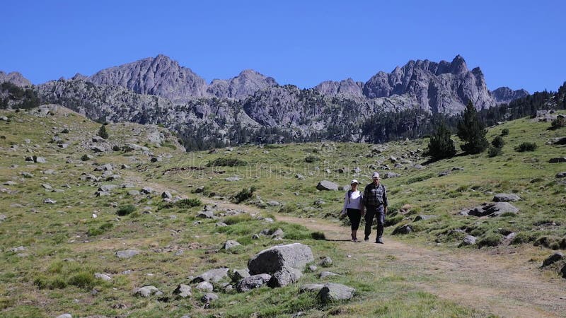 Tourists walking on Spanish Pyrenees Mountain in a sunny day
