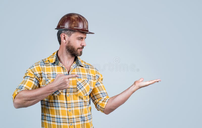 Le Gars Porte Un Uniforme De Travailleur. Beau Constructeur En Casque. Homme  Mûr Porter Une Chemise À Carreaux Banque D'Images et Photos Libres De  Droits. Image 169259230