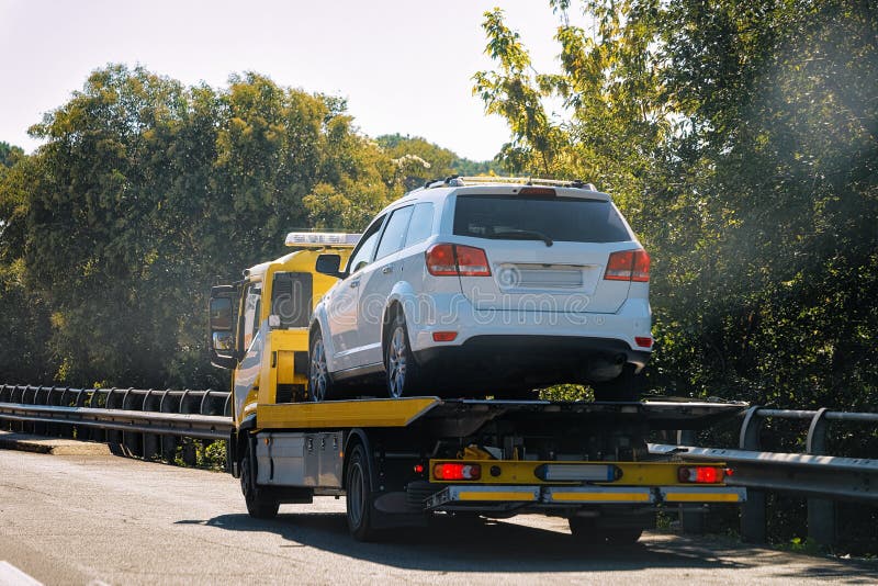Tow truck with car on road stock image. Image of road 128070493