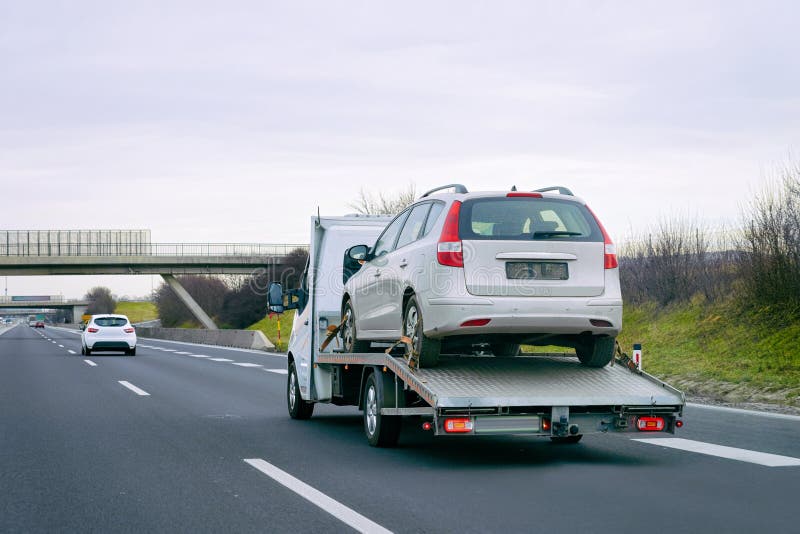 Tow truck with car on warranty on road