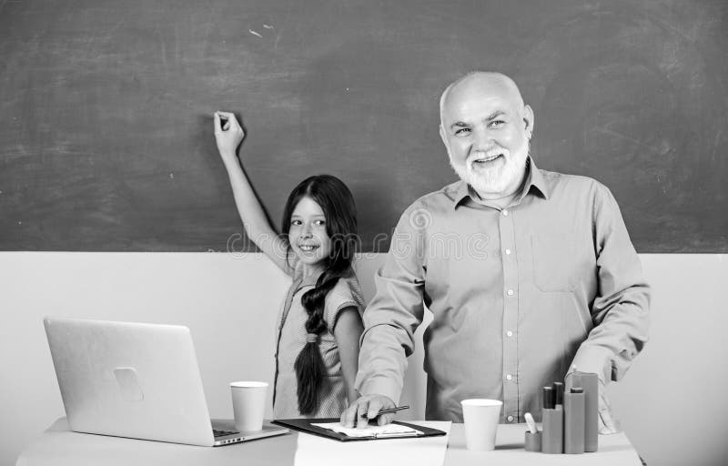 Towards knowledge. ature teacher help school girl. little girl with man tutor study on laptop. new technology in royalty free stock images Towards knowledge. ature teacher help school girl. little girl with man tutor study on laptop. new technology in royalty free stock images