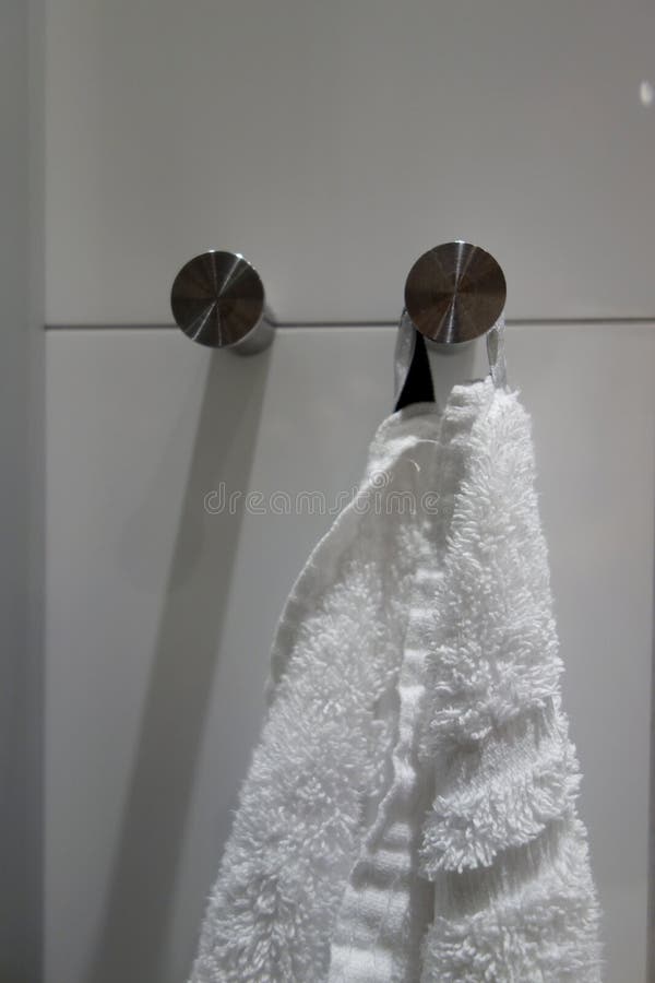 A Towel Hung on a Hanger in the Bathroom of a Hotel Room Stock Photo
