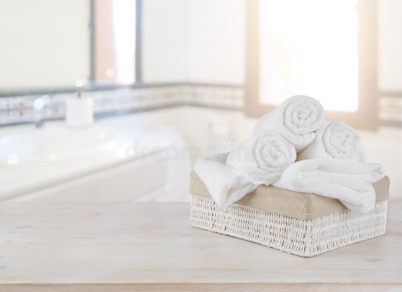 Towels in basket on wooden table over defocused bathroom background royalty free stock images Towels in basket on wooden table over defocused bathroom background royalty free stock images