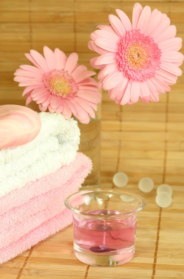 Towels, soap, candle and flowers.