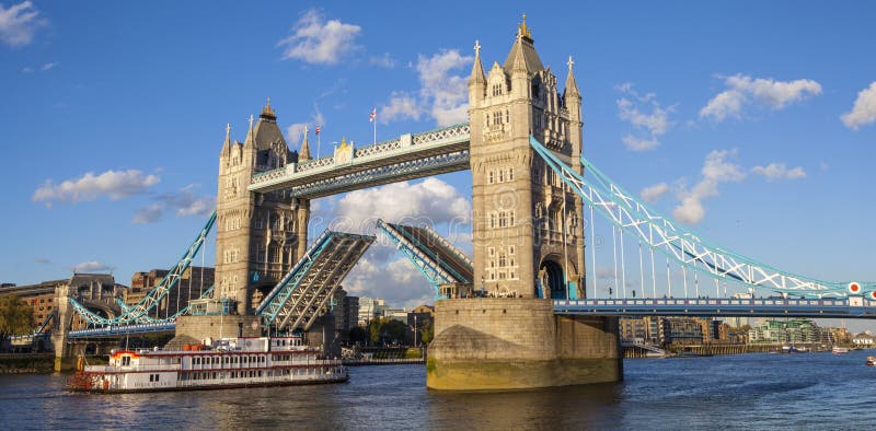 A panoramic view of Tower Bridge opening up over the River Thames to let a vessel pass underneath. A panoramic view of Tower Bridge opening up over the River Thames to let a vessel pass underneath.