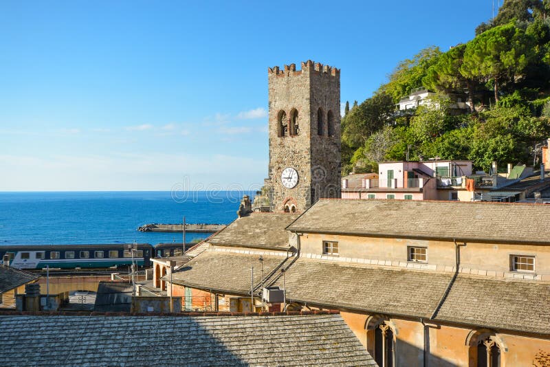 The tower of Chiesa di San Giovanni Battista with the Ligurian sea beyond as a train passes in Monterosso al Mare, Italy. The tower of Chiesa di San Giovanni stock image The tower of Chiesa di San Giovanni Battista with the Ligurian sea beyond as a train passes in Monterosso al Mare, Italy. The tower of Chiesa di San Giovanni stock image