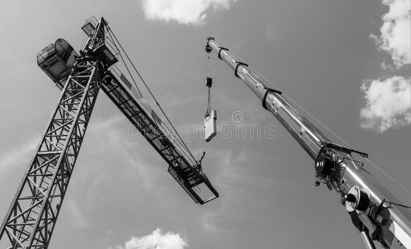 Tower crane assembly. Concrete counterweight installation. Artistic black and white skyline