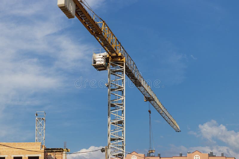 Tower crane close-up on a background of blue sky. Modern housing construction. Industrial engineering. Construction of mortgage