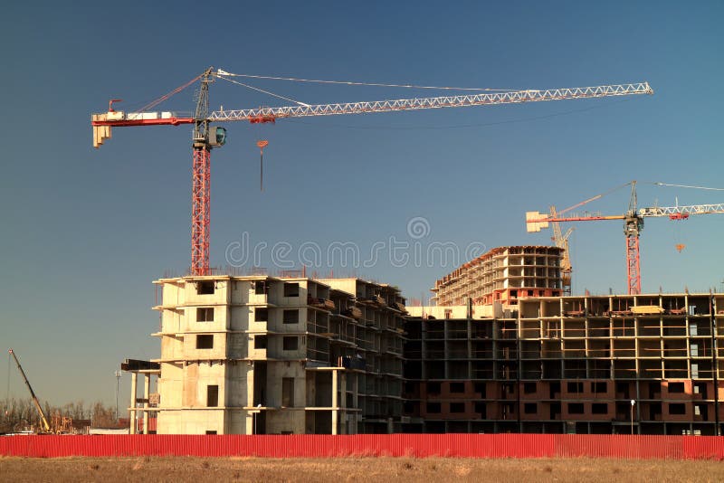 Tower Cranes are Working on the Construction of a New House. Lifting