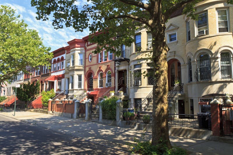 A row of attached brick apartment buildings with stoops on Lincoln Place in the Crown Heights neighborhood of Brooklyn, NY. A row of attached brick apartment buildings with stoops on Lincoln Place in the Crown Heights neighborhood of Brooklyn, NY