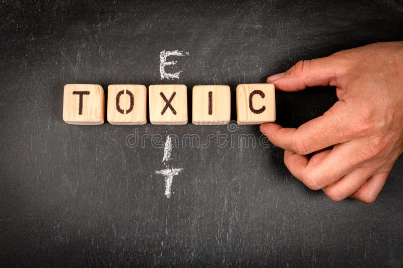 TOXIC and EXIT Wooden Block Crossword Puzzle and Pieces of Chalk on a TOXIC and EXIT Wooden Block Crossword Puzzle and Pieces of Chalk on a