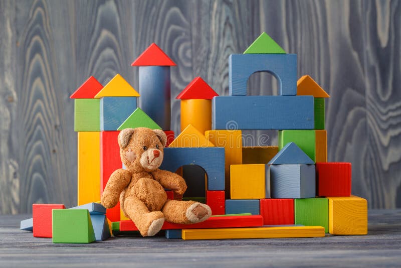 Toy bear and pile wooden building blocks. Game, background.