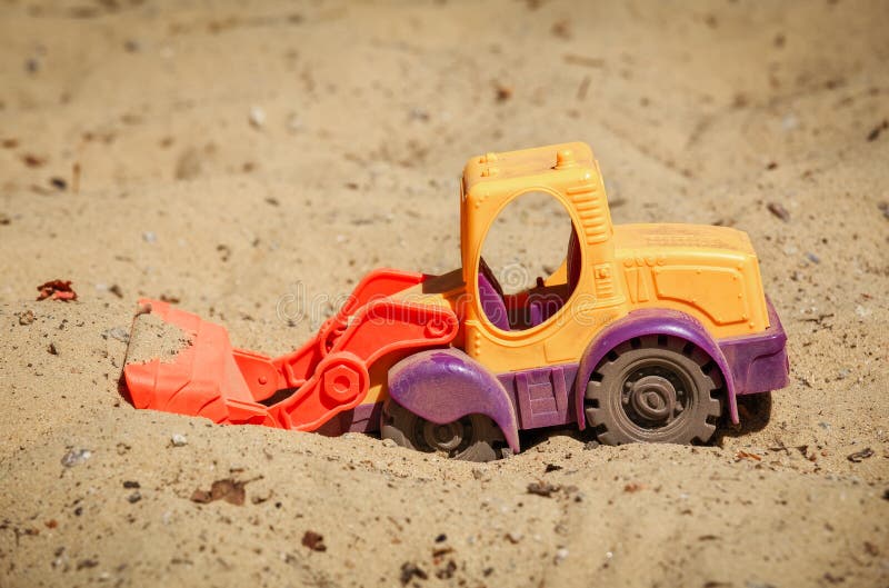 Toy Bulldozer i sanden En liten grävare fotografering för bildbyråer Toy Bulldozer i sanden En liten grävare fotografering för bildbyråer