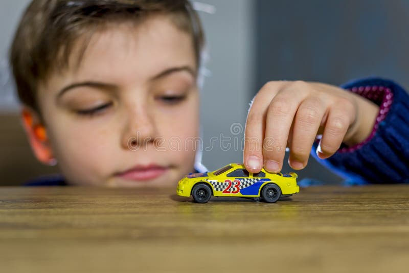 Boy playing with toy car on a table, shallow depth of field