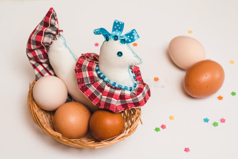 Toy Chicken and Colored Chicken Eggs in a Wicker Brown Basket and