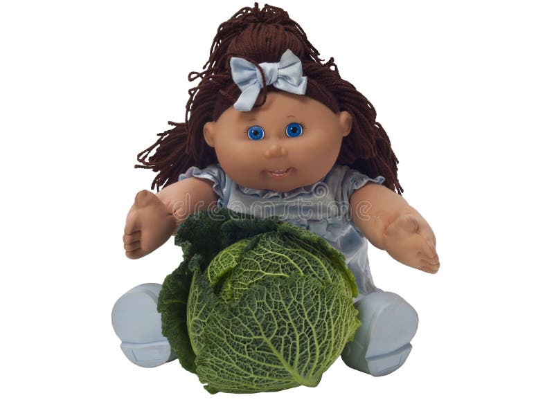 Toy doll sitting behind a cabbage