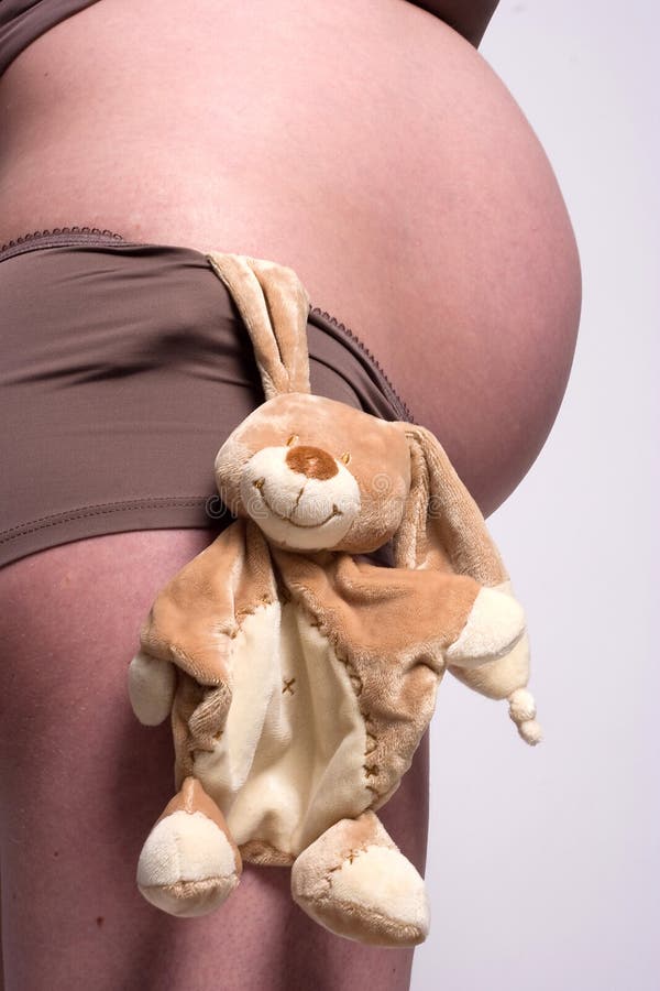 A toy hanging by a pregnant belly