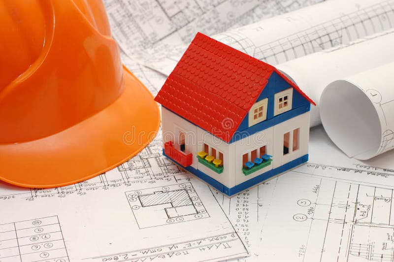 Toy house model on blueprints with helmet near by royalty free stock images