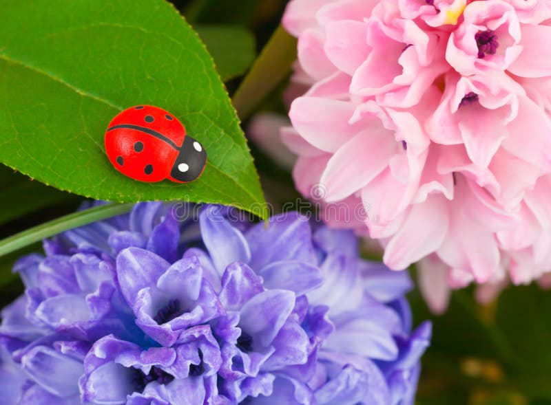Toy ladybug and flowers, abstract nature background